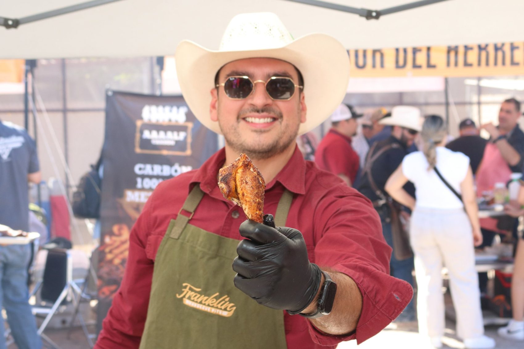 Parrillero con sombrero mostrando un trozo de carne